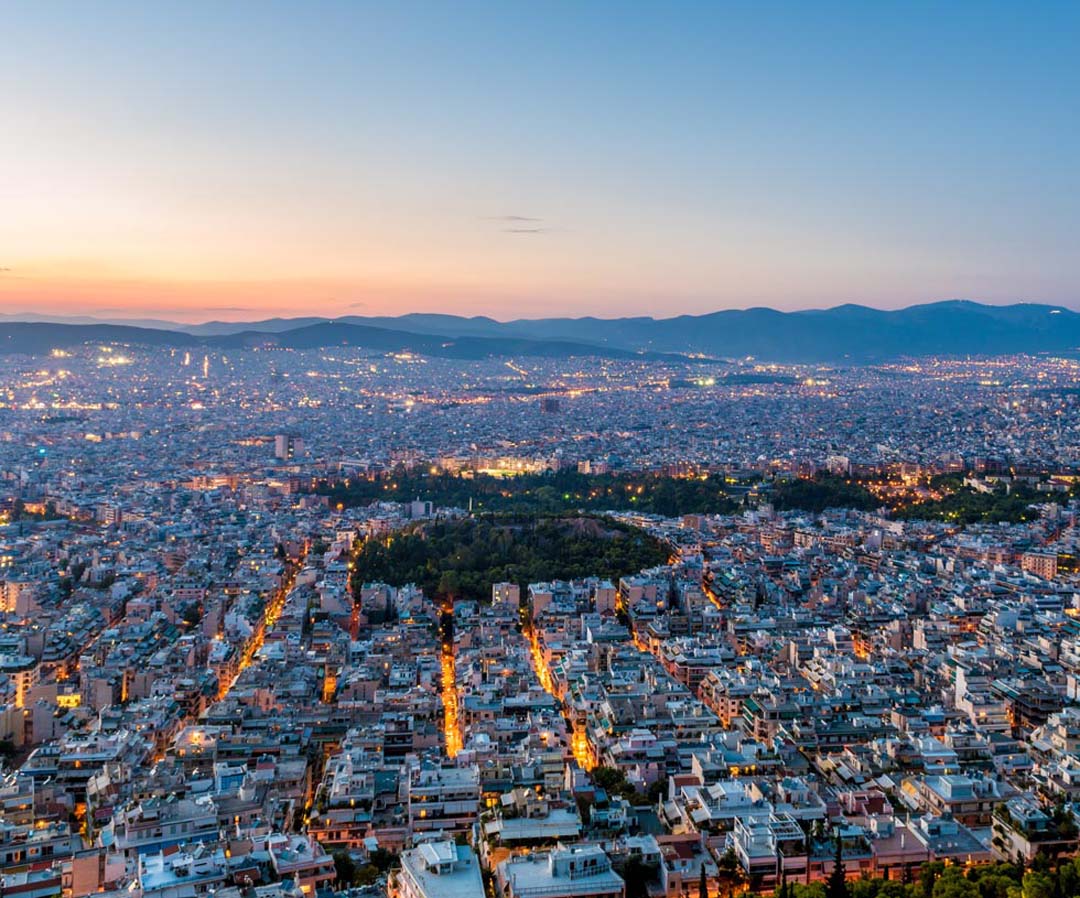 Night in Athens with sunset colors over the mountains