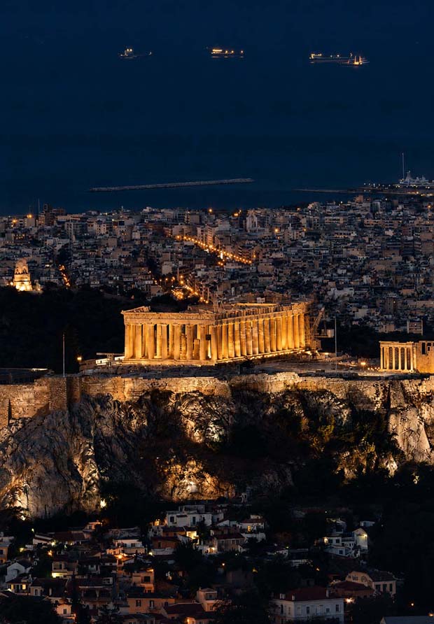 At night with the Saronic Gulf in the background looking over the Parthenon in Athens